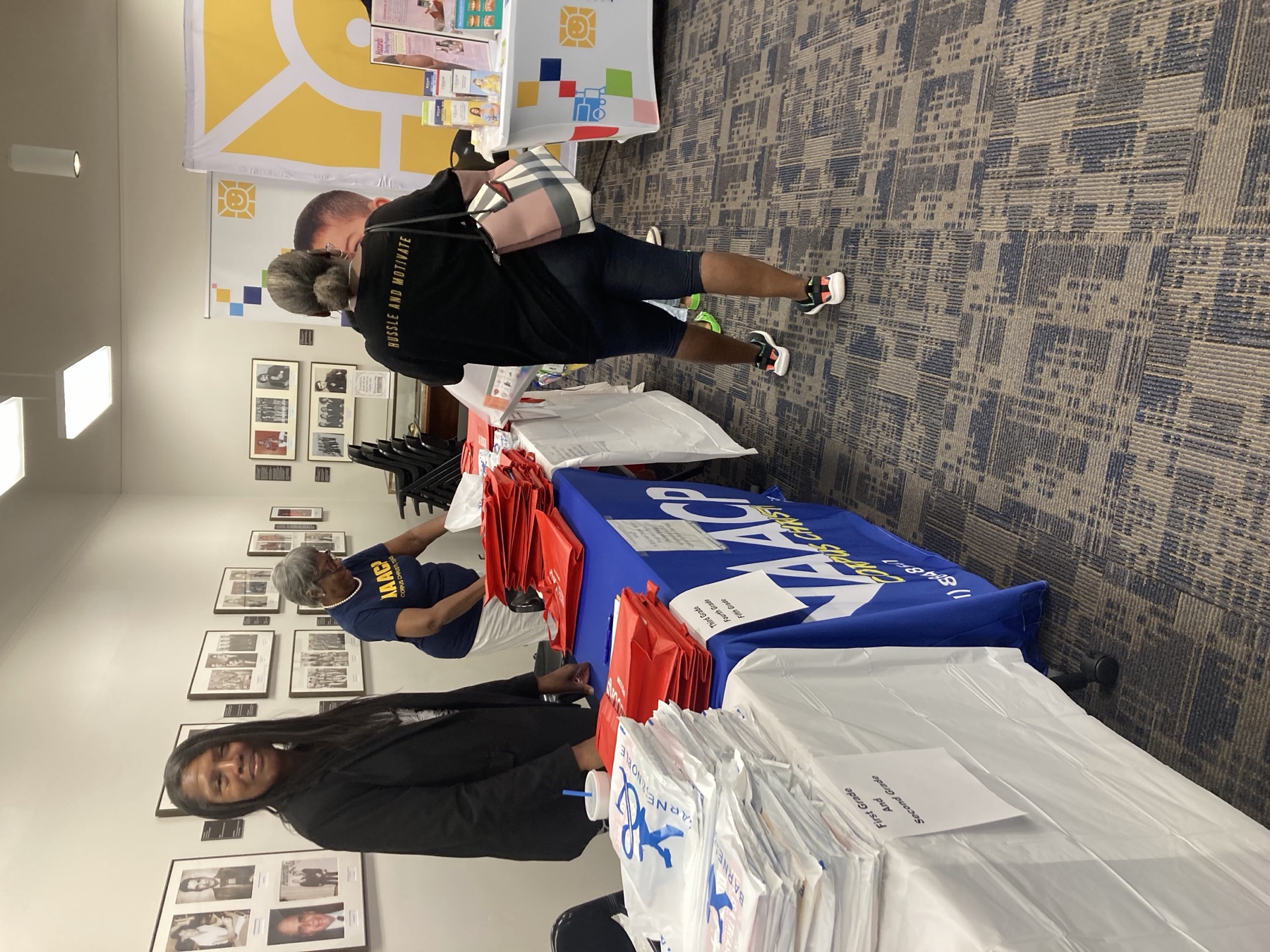 Volunteer in an NAACP shirt preparing school-supply bags